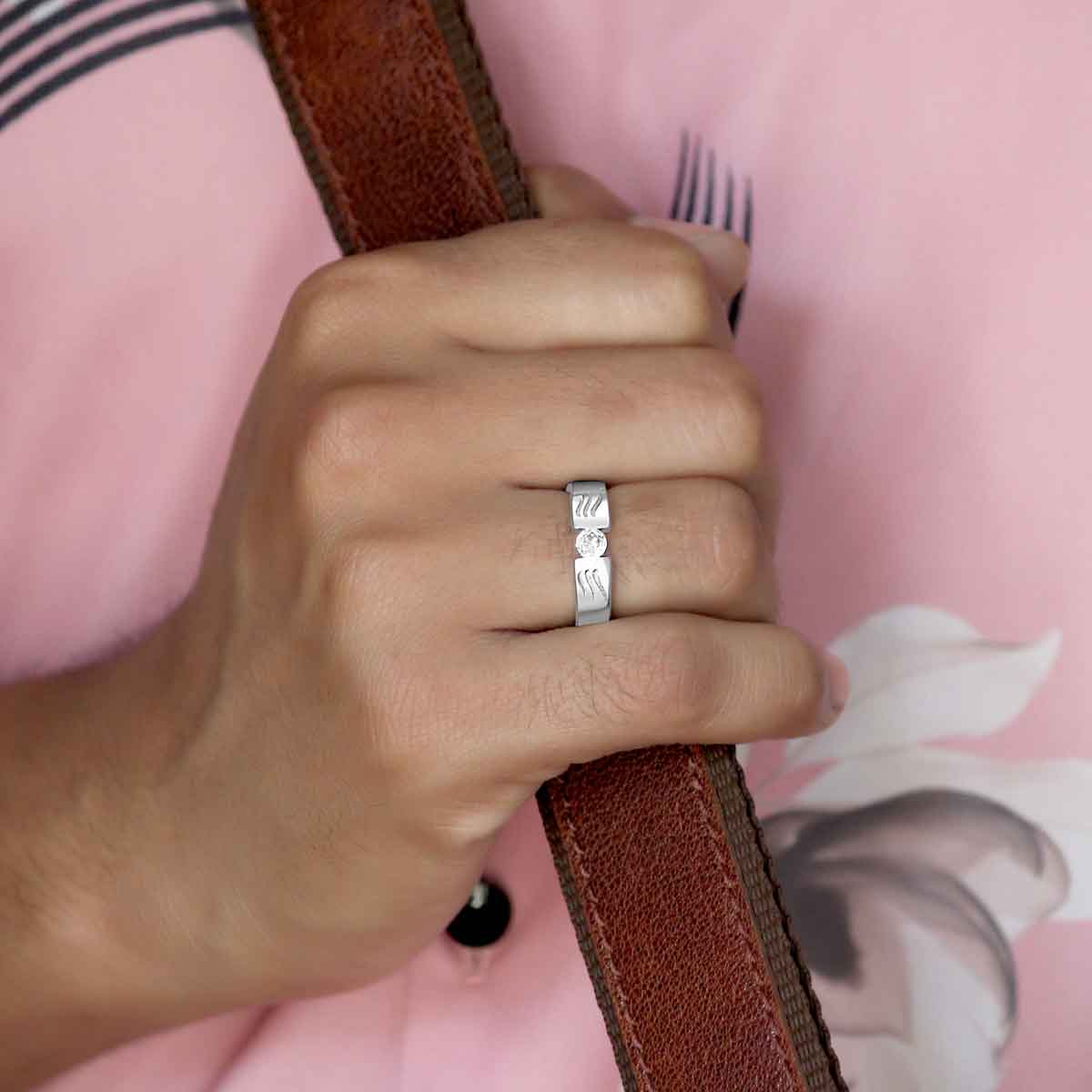 This sterling silver band features a unique wave design engraved with sparkling round zirconia, making it a stylish and versatile accessory for everyday wear. Crafted with a rhodium finish, it is a thoughtful gift option for men.