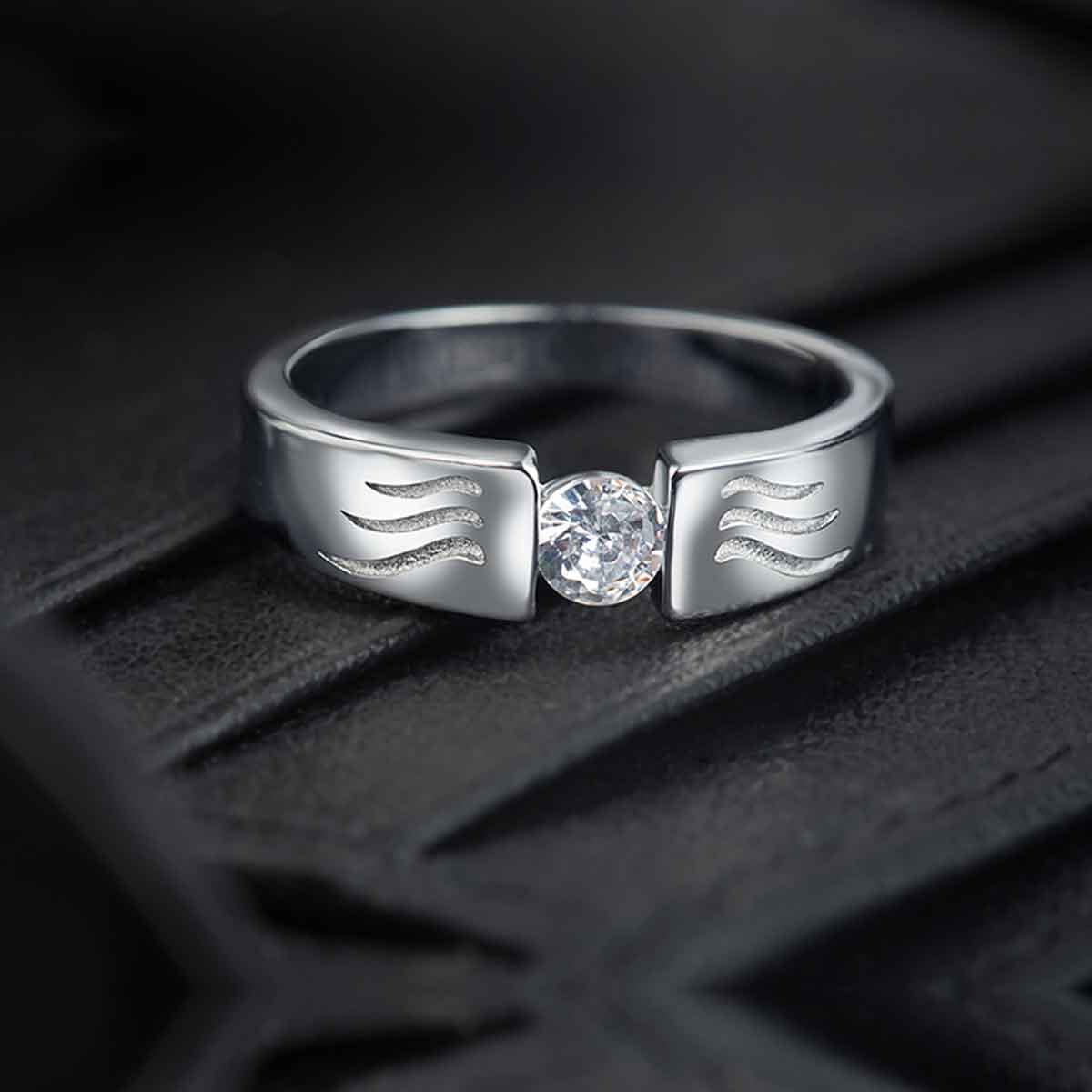 This sterling silver band features a unique wave design engraved with sparkling round zirconia, making it a stylish and versatile accessory for everyday wear. Crafted with a rhodium finish, it is a thoughtful gift option for men.