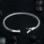 Close-up of Compassionate wide sterling silver men's bracelet showing barrel-style tube clasp and safety lock