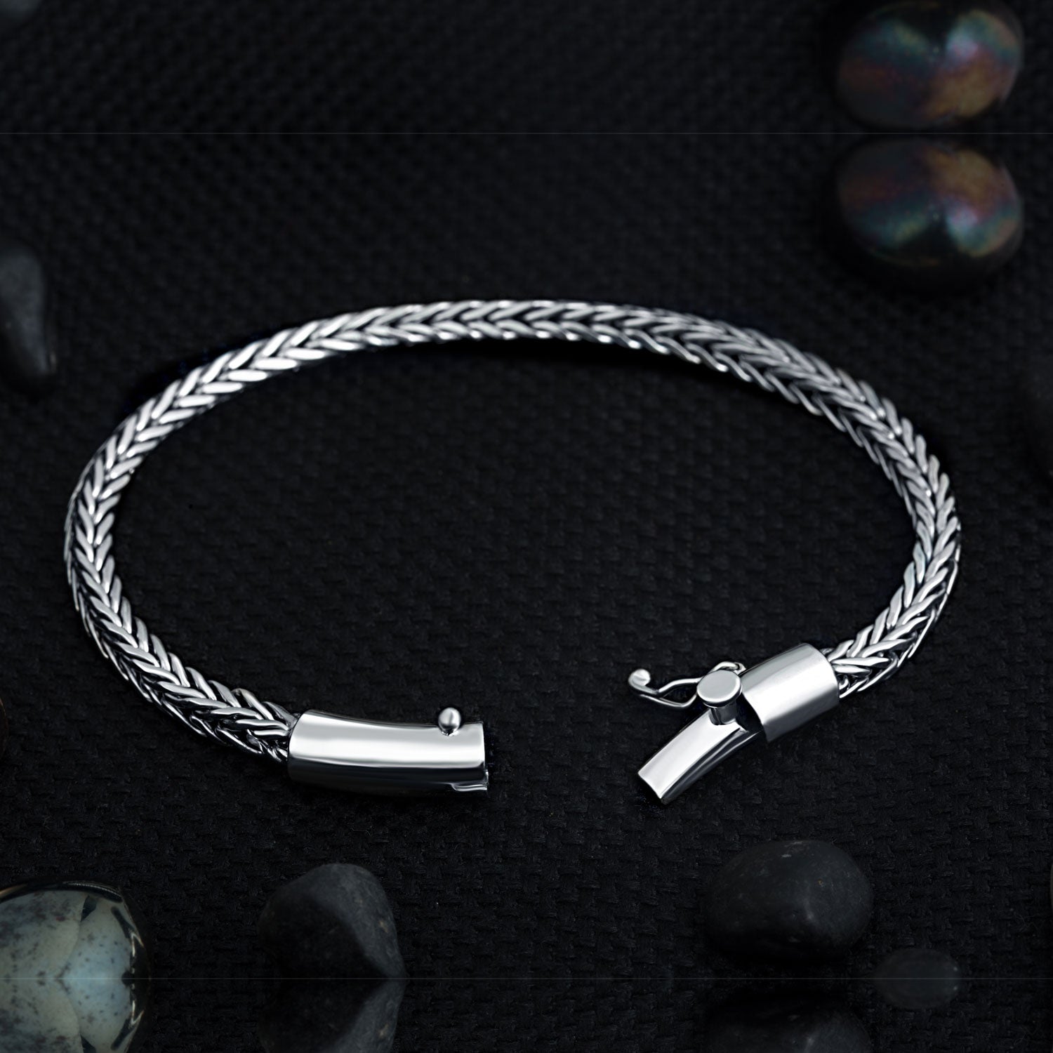 Close-up of Compassionate wide sterling silver men's bracelet showing barrel-style tube clasp and safety lock