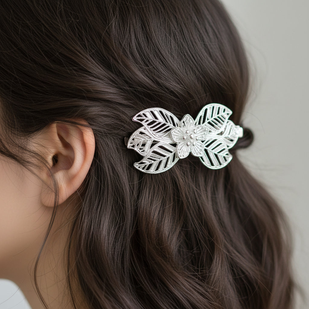 A sterling silver hair clip with a floral design, featuring intricate details on the petals.