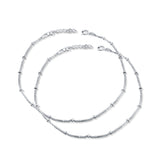 A pair of silver hook closure anklets for women.


