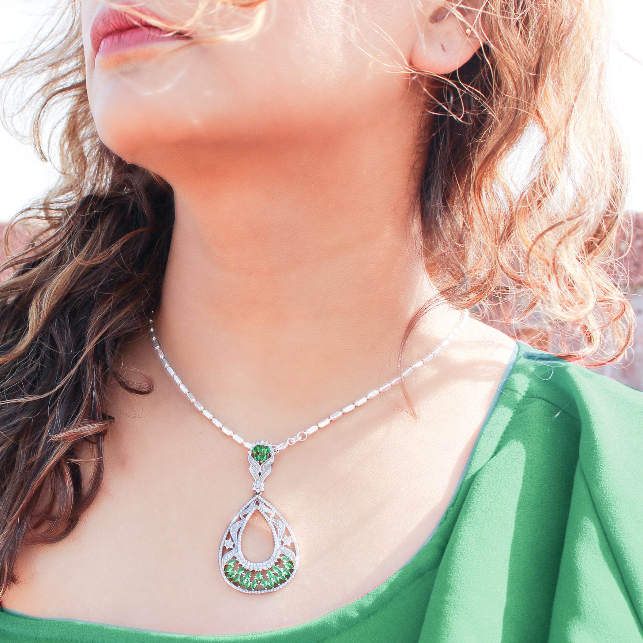 92.5 sterling silver pendant studded with white and green zirconias in the shape of drop 